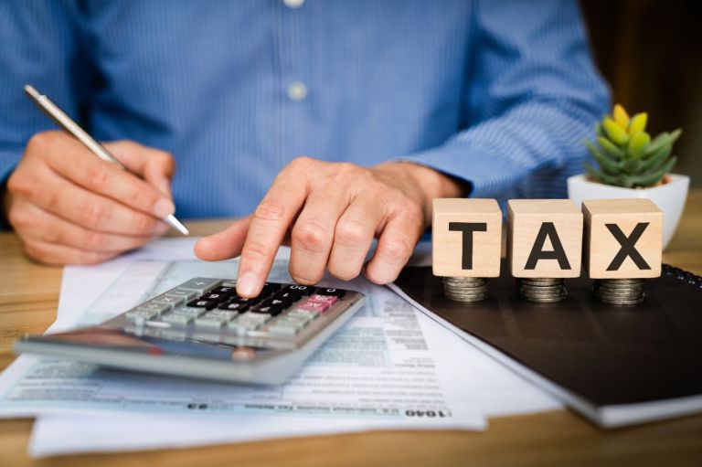 Calculatrice et documents fiscaux illustrant la TVA sur les murs commerciaux